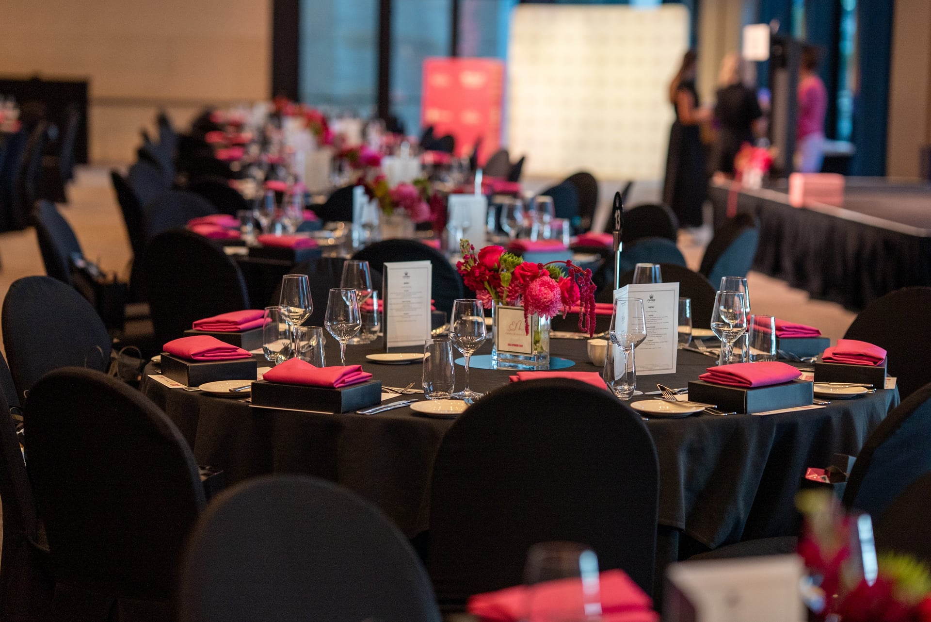 A styled Beam Awards gala table set with pink florals and menus